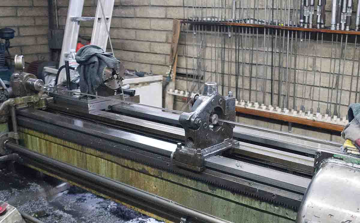 This dual-spindle, deep-hole drill and reaming machine (Pratt & Whitney) is used for new barrels and for reboring. In the background are finish bore reamers and counter bores. It may take up to five reamers rotating at 350 rpm and reaming up to 2 inches per minute to reach a desired bore diameter.